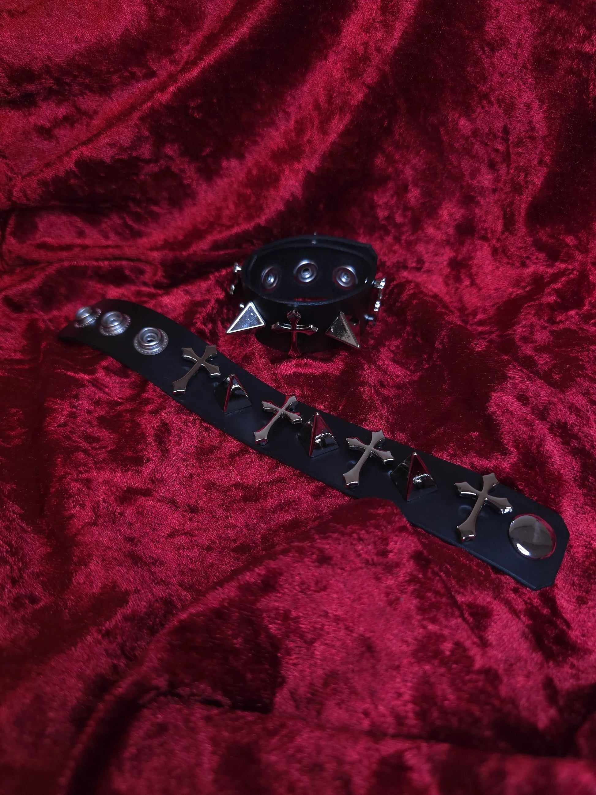 Black leather bracer with metal studs and spikes on a red velvet background