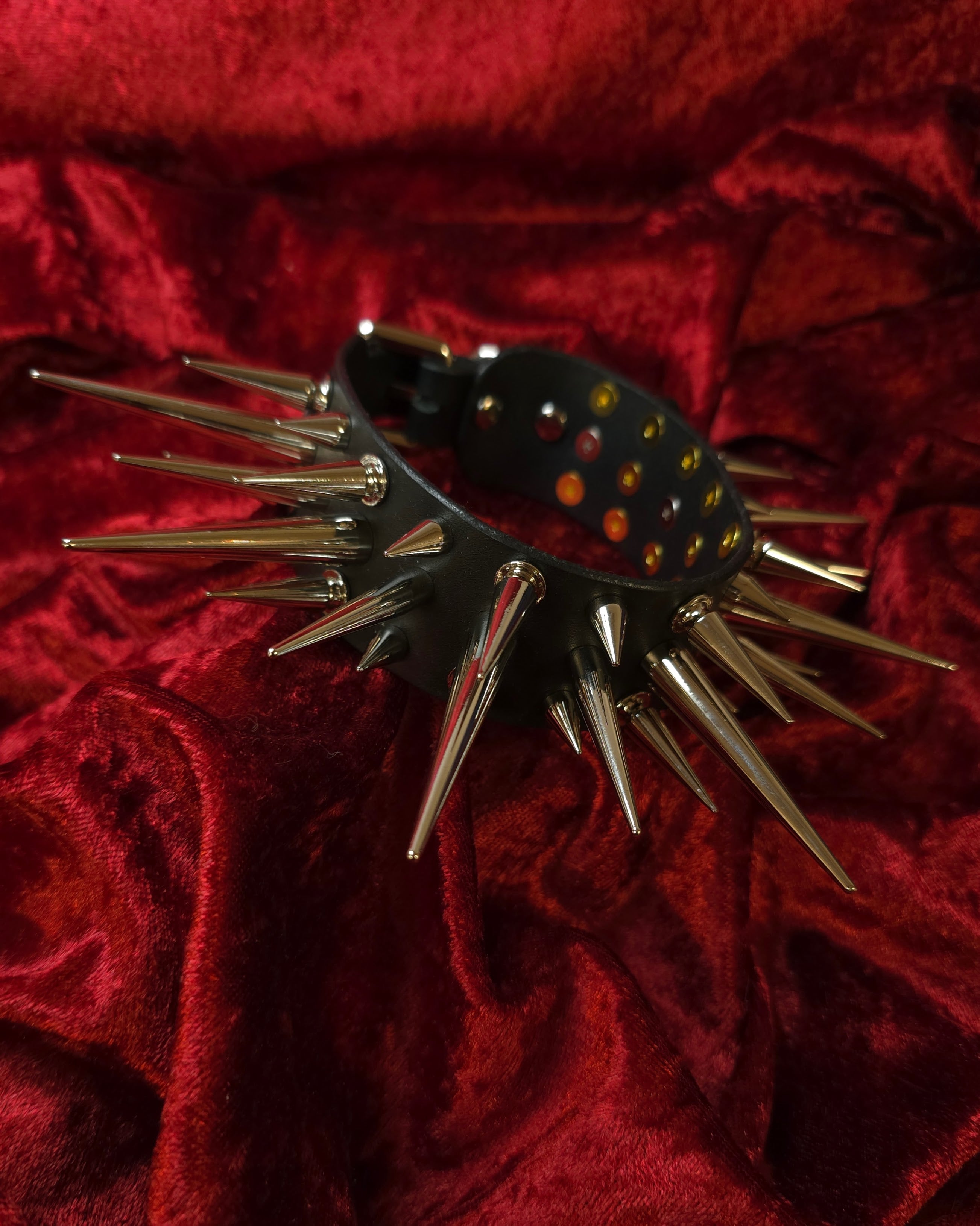 Black spiked collar on a red textured background
