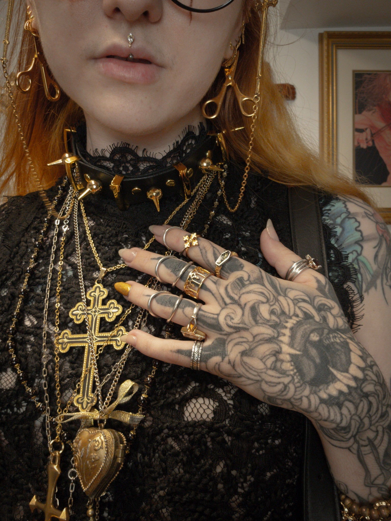 Person with tattoos and gold jewelry in a close-up shot