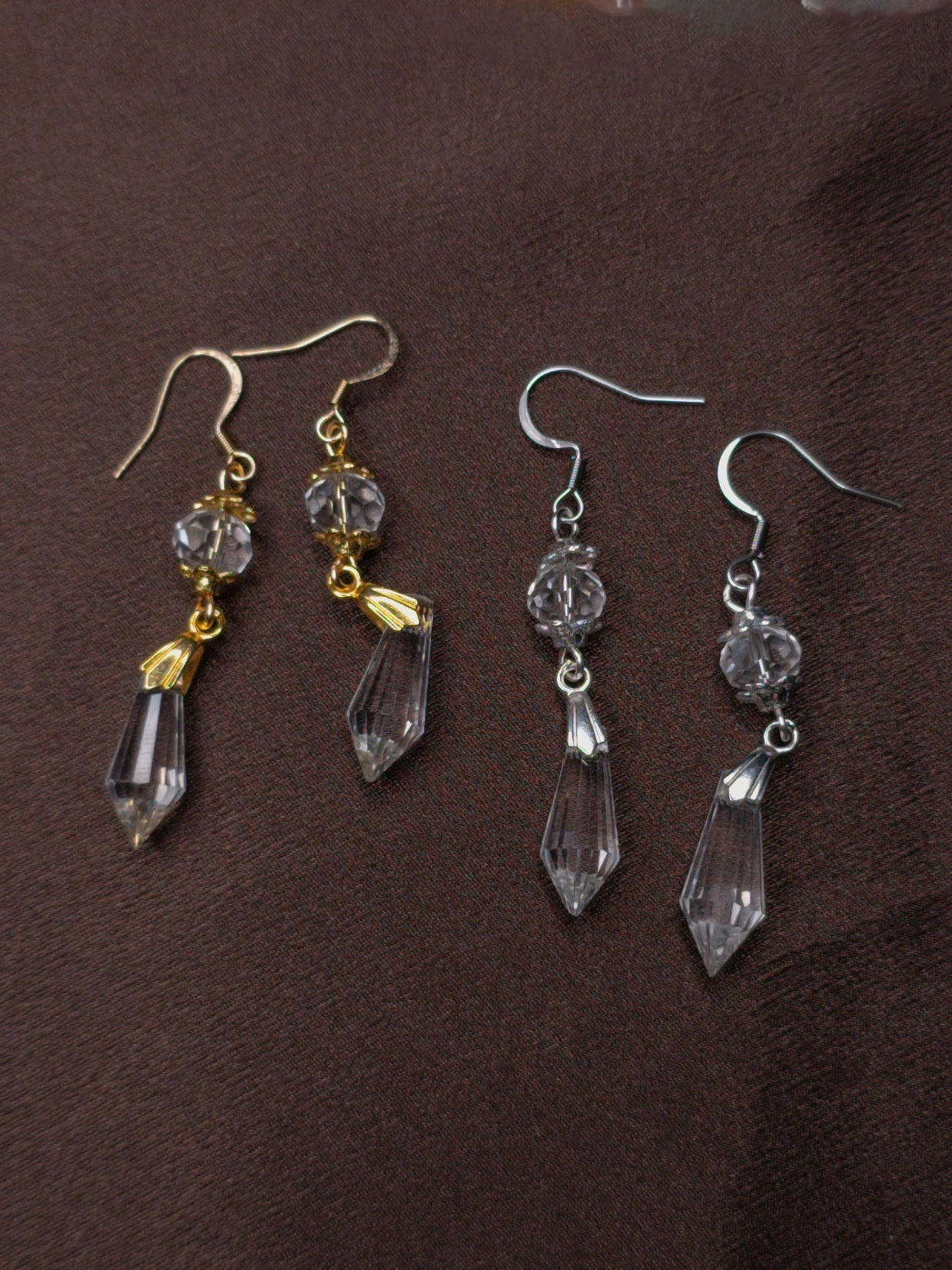 Pair of crystal drop earrings on a brown background