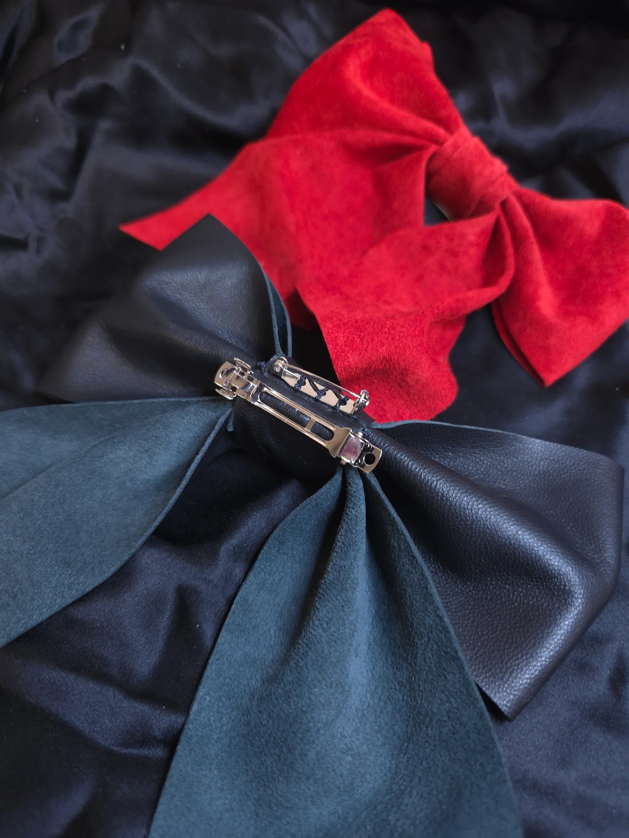 Back side of leather bow showing hair clip and brooch pin