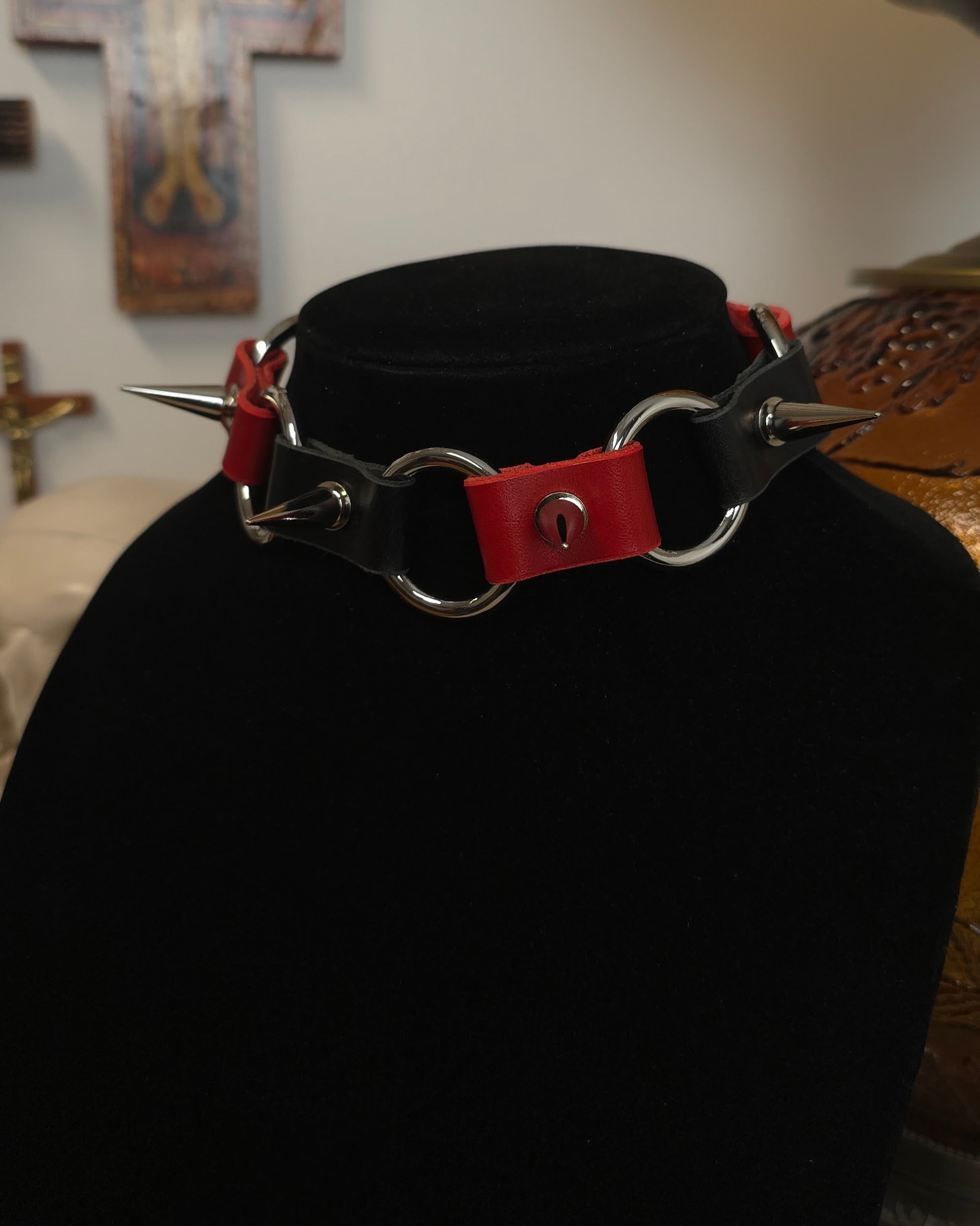 Black choker with red accents and spikes on a black background