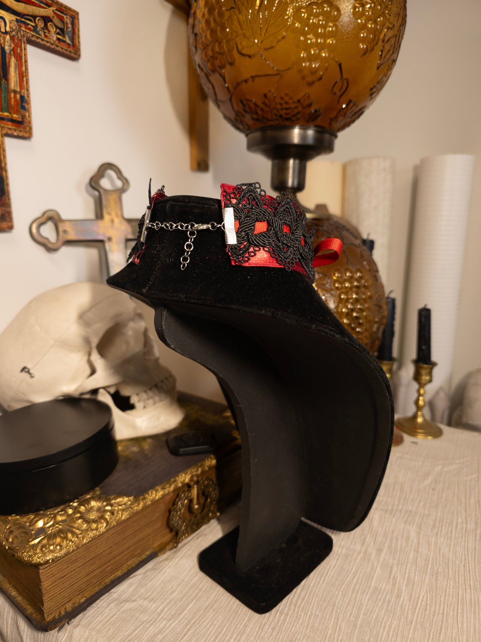 black necklace display with red ribbon choker against gothic decor