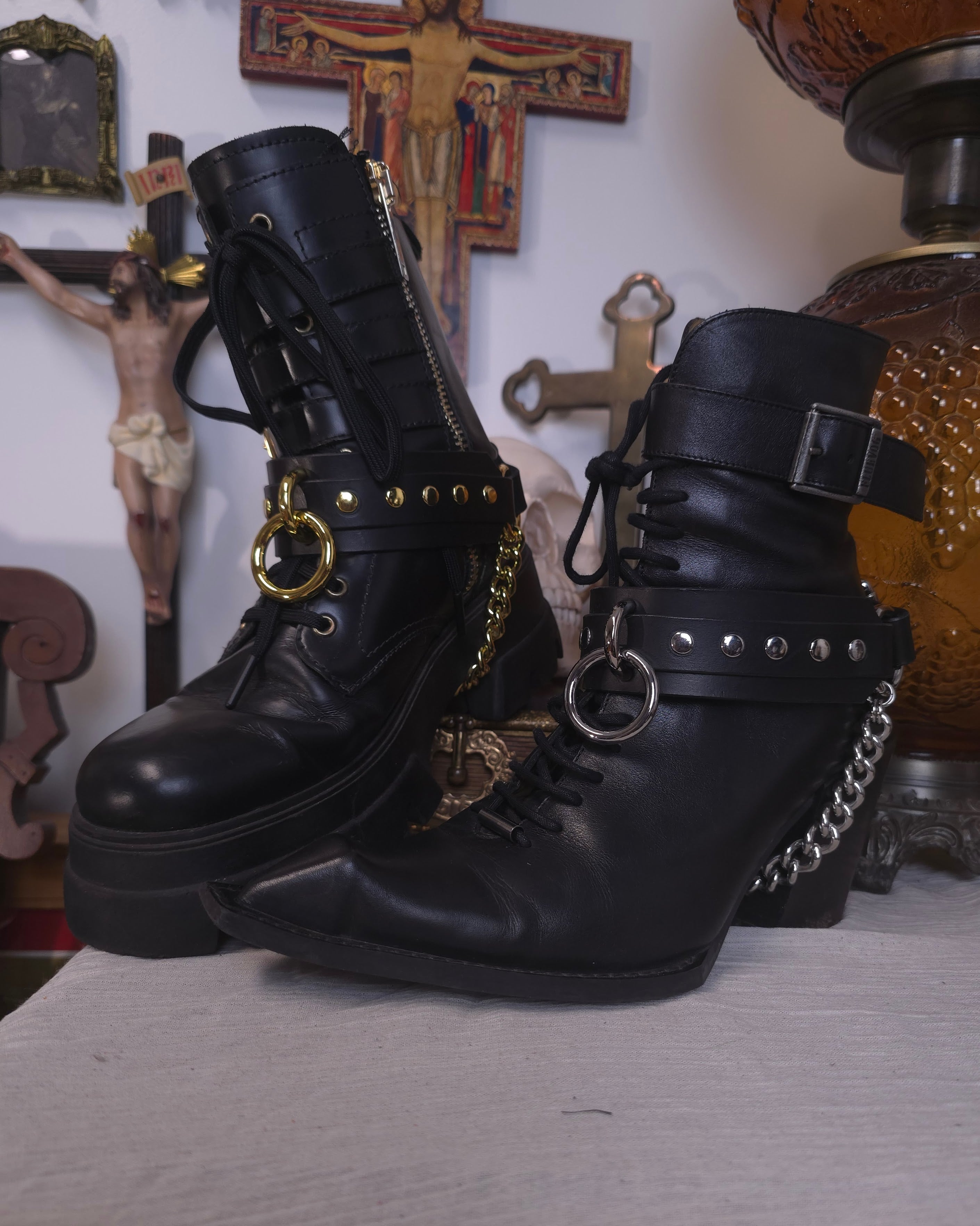 black boots with leather belts with silver and golden studs
