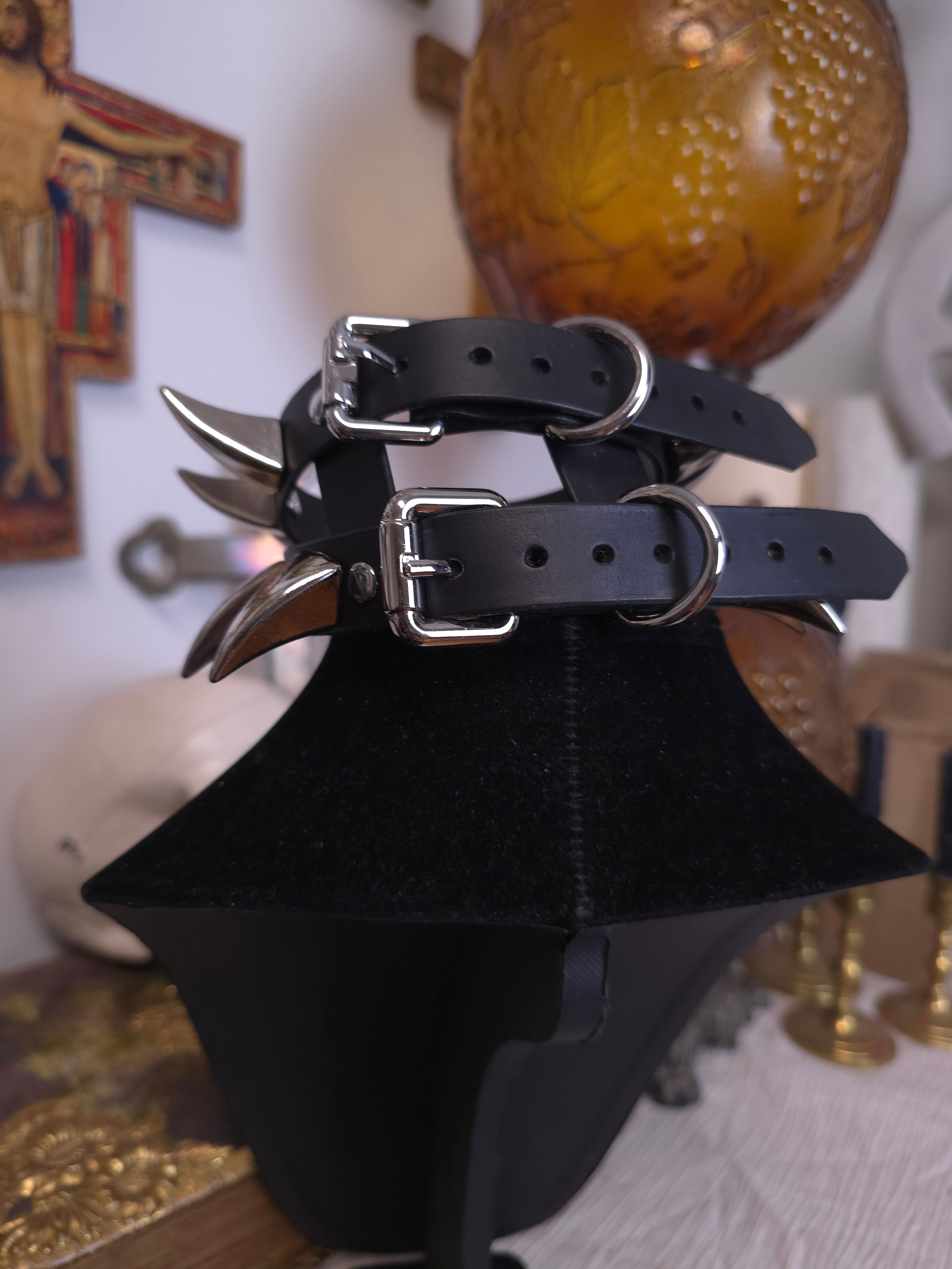 back view of black neck form wearing a black leather collar with silver hardware
