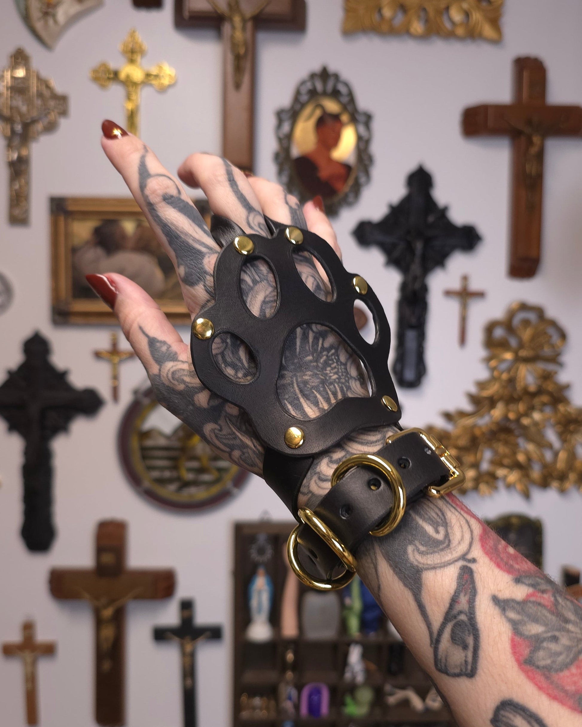 hand wearing black paw shaped leather