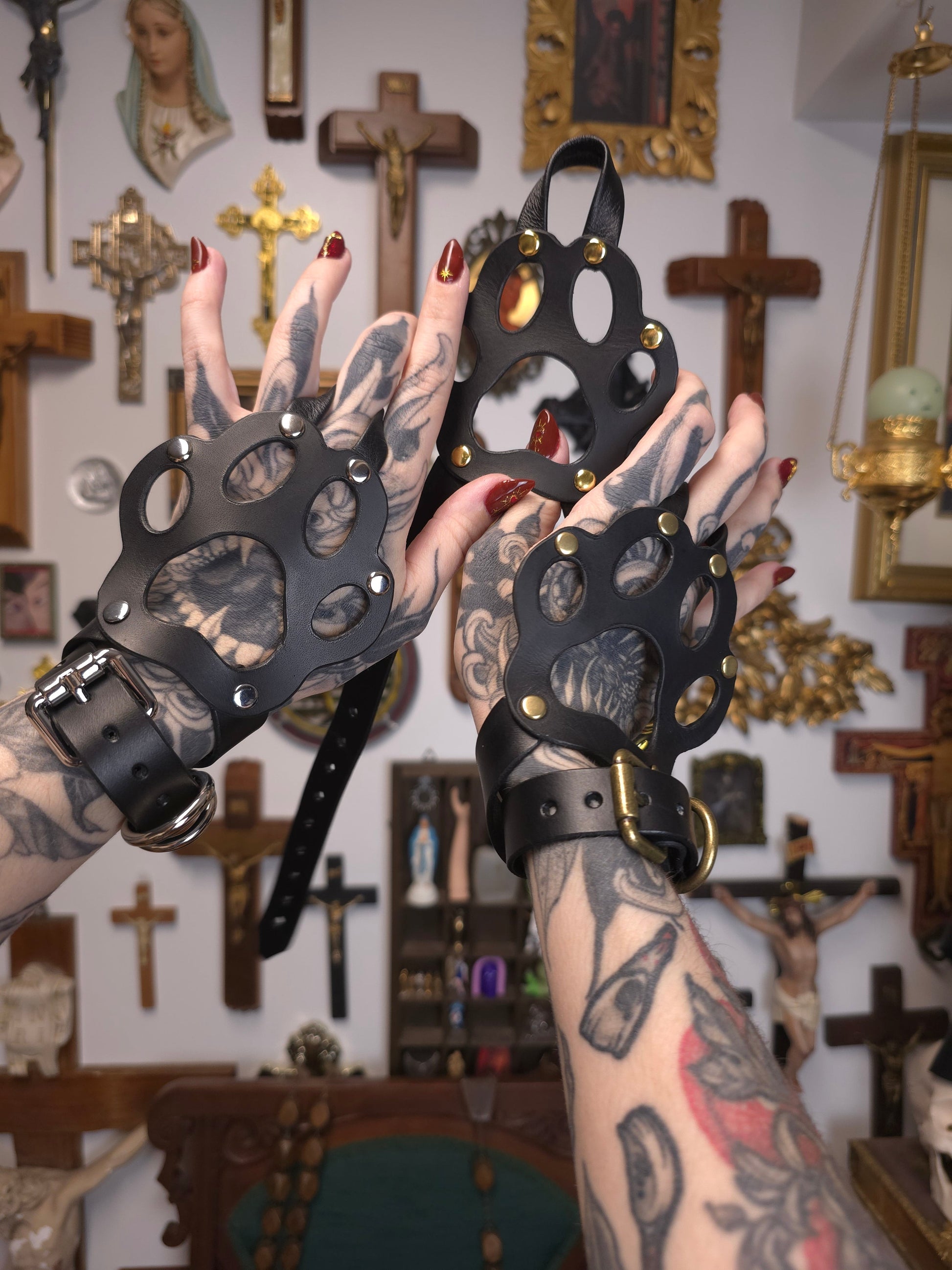 two hands wearing leather paws holding an extra paw