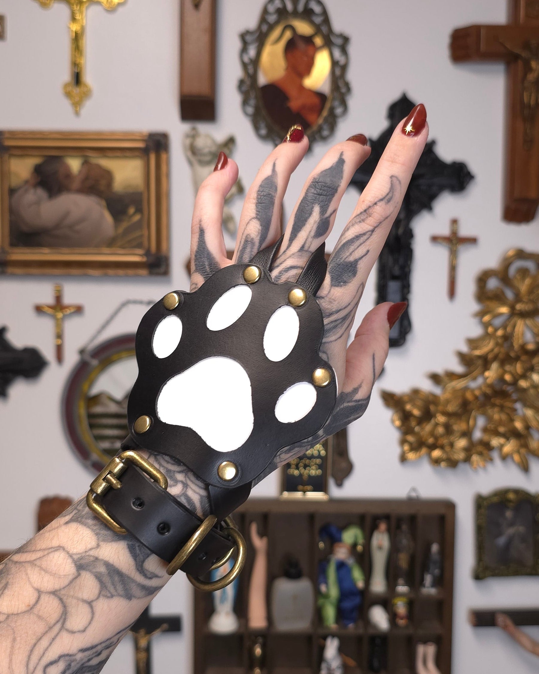 Hand wearing black and white paw shaped accessory