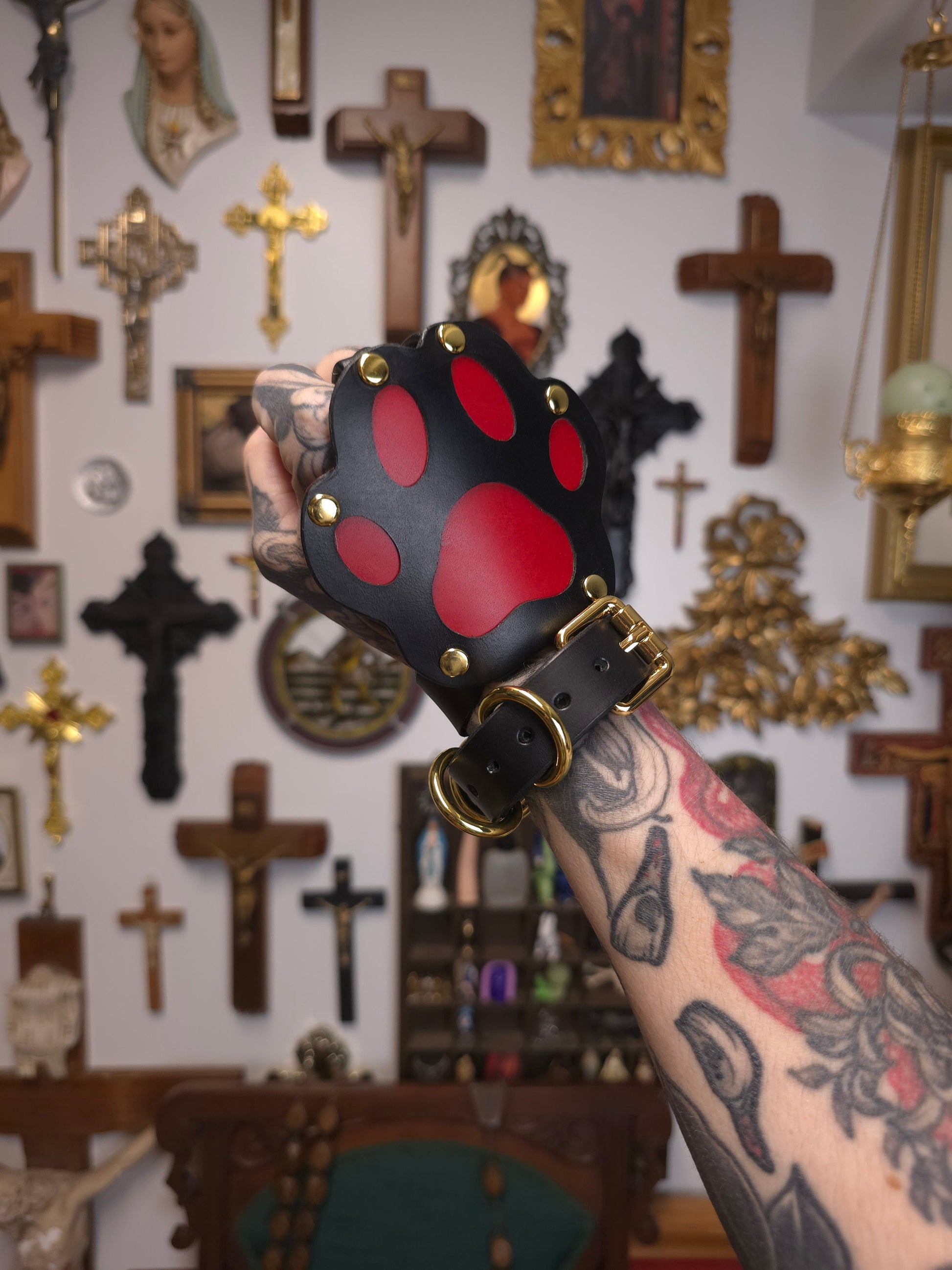 hand in a fist wearing black and red leather paw