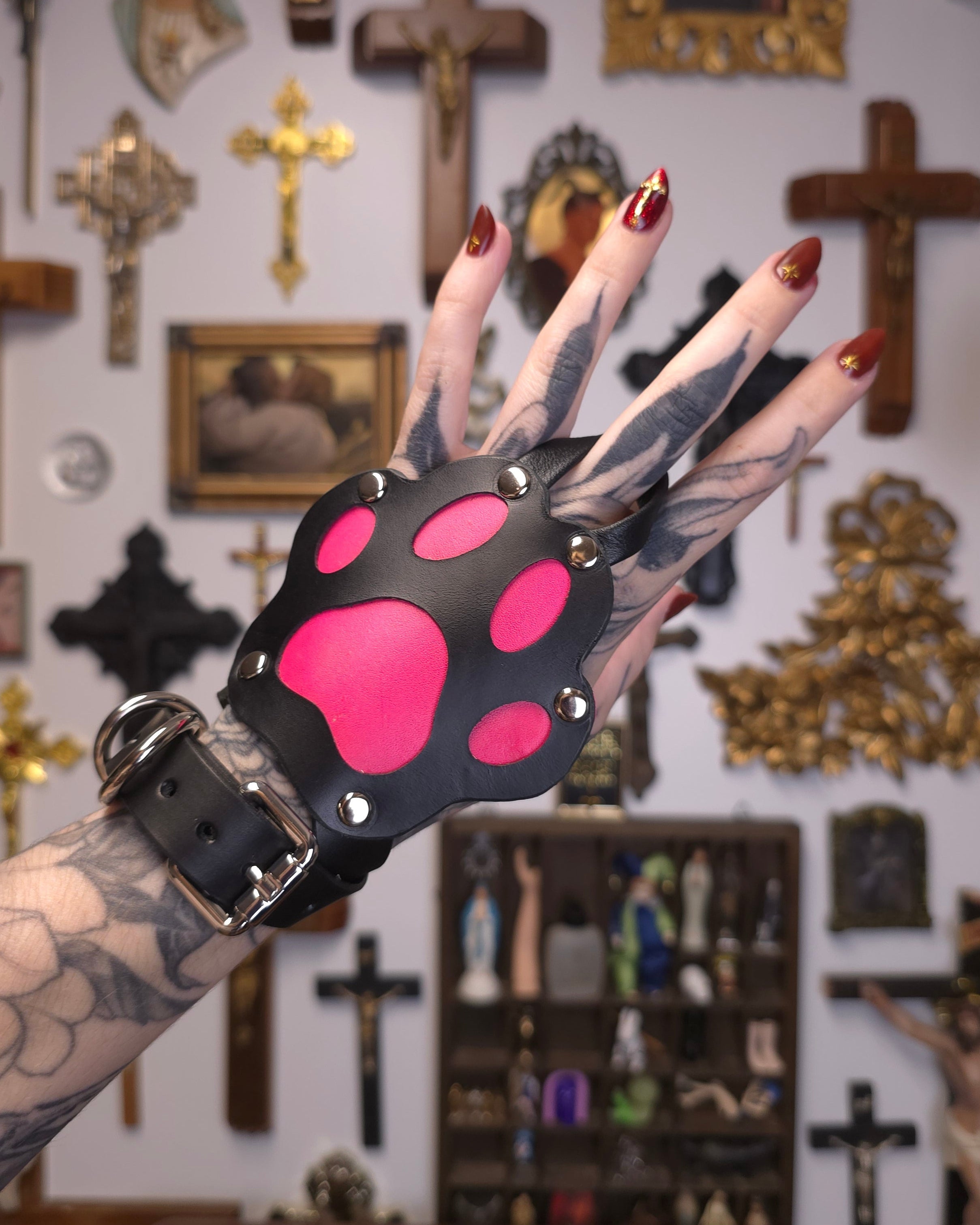 hand wearing a black and pink paw accessory 