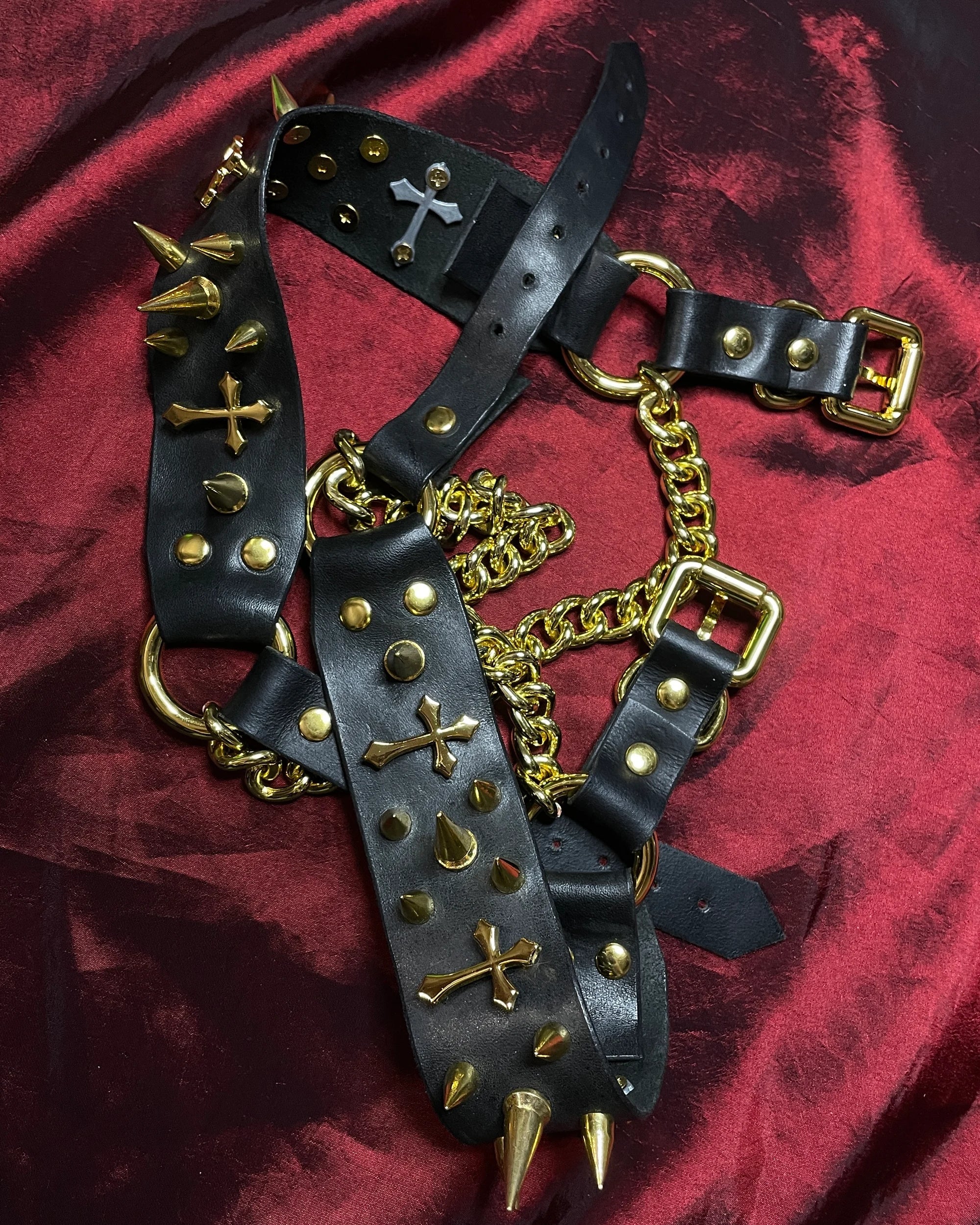 black leather shoe belts laid on a red backg