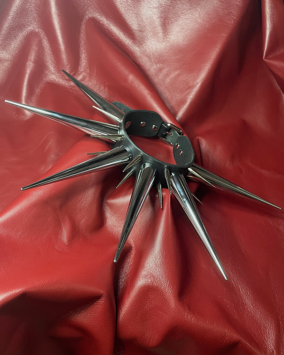 Spiked leather collar on a red leather background