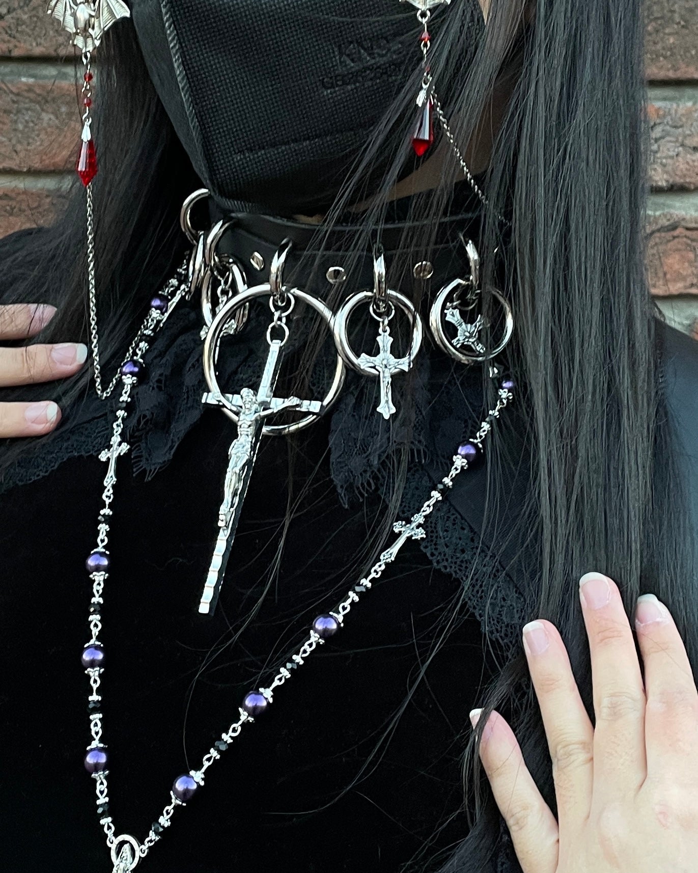 person wearing black and silver choker with large cross