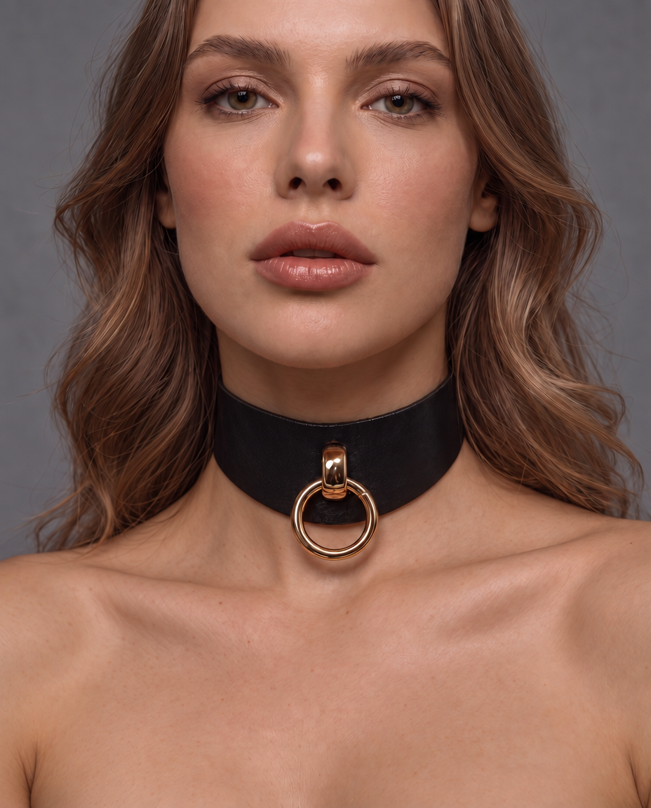 woman wearing a black leather collar with gold  O-ring at the front