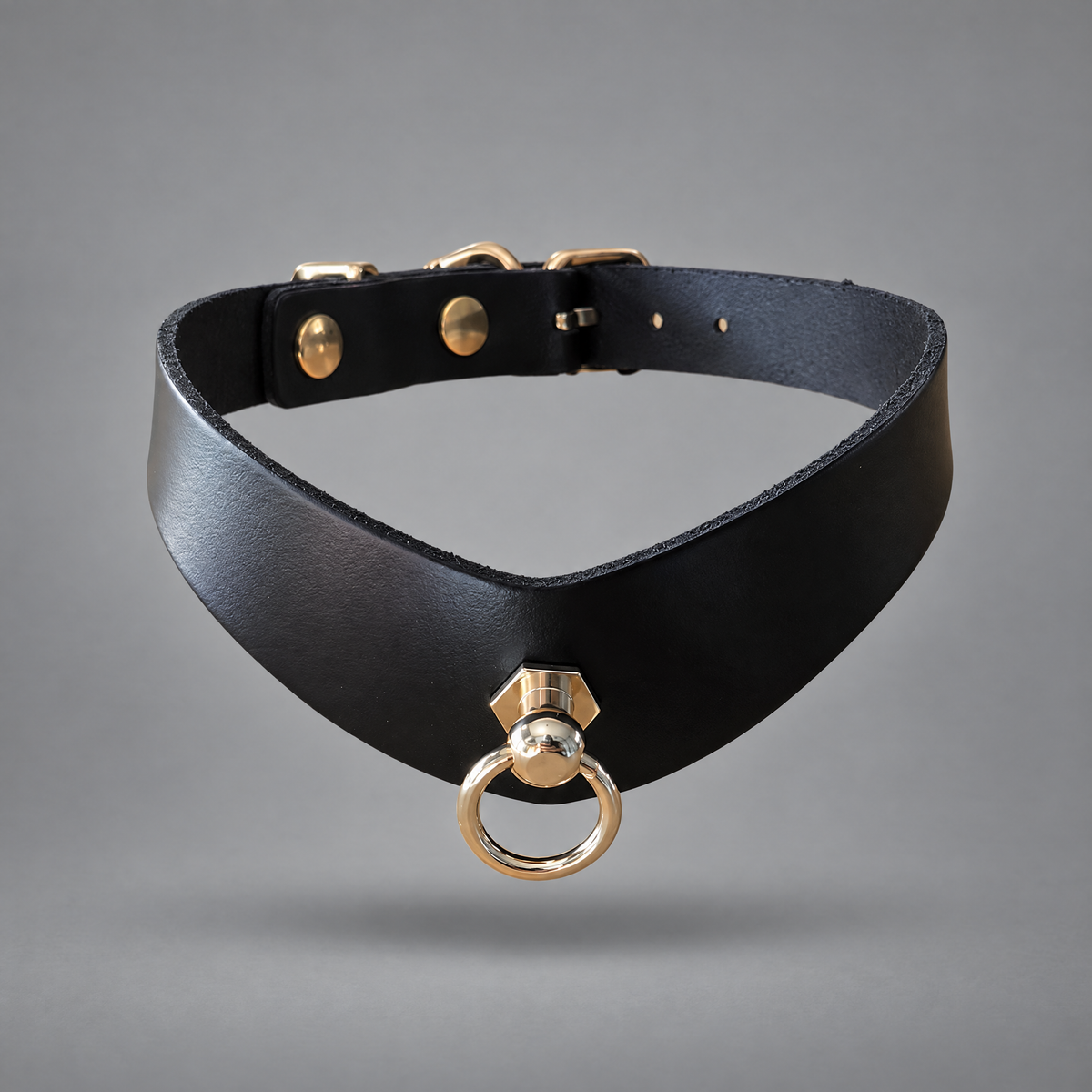 A black high-end leather bdsm collar with gold-tone hardware, featuring a swivel ring