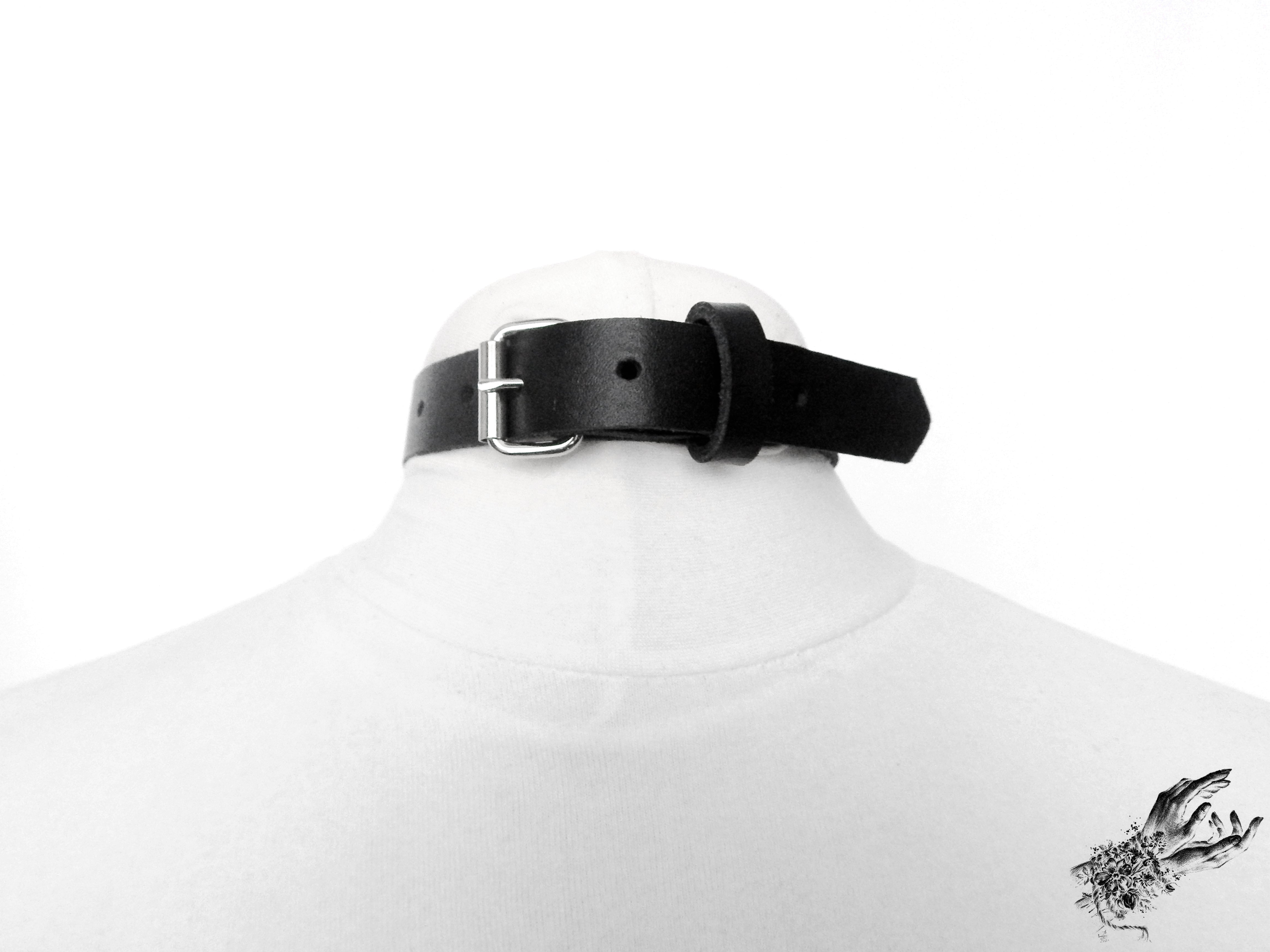 Rear view photo of a black bound heart ring collar, showing the stainless steel plated buckle fastening and adjustable sizing holes. Displayed on a mannequin against a white background.
