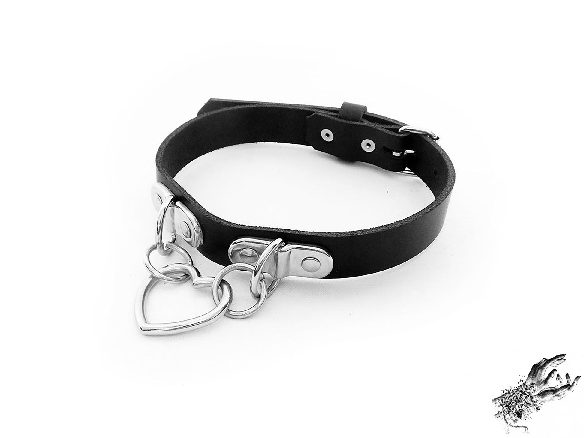 Handmade black leather collar featuring a central silver heart ring suspended by two D ring plates. Displayed on a white background.