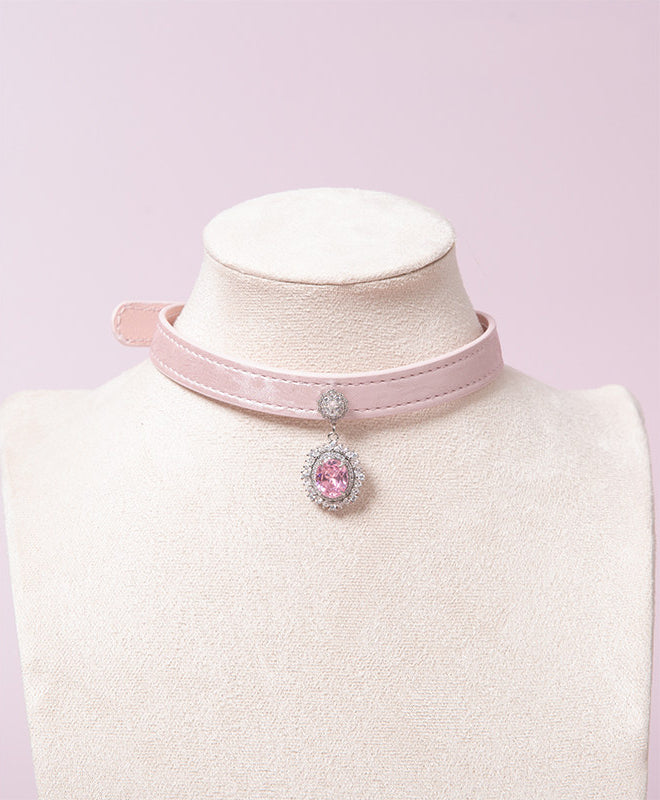 pink leather collar featuring a silver and pink crystal cameo pendant, displayed on a white mannequin against a pink background.