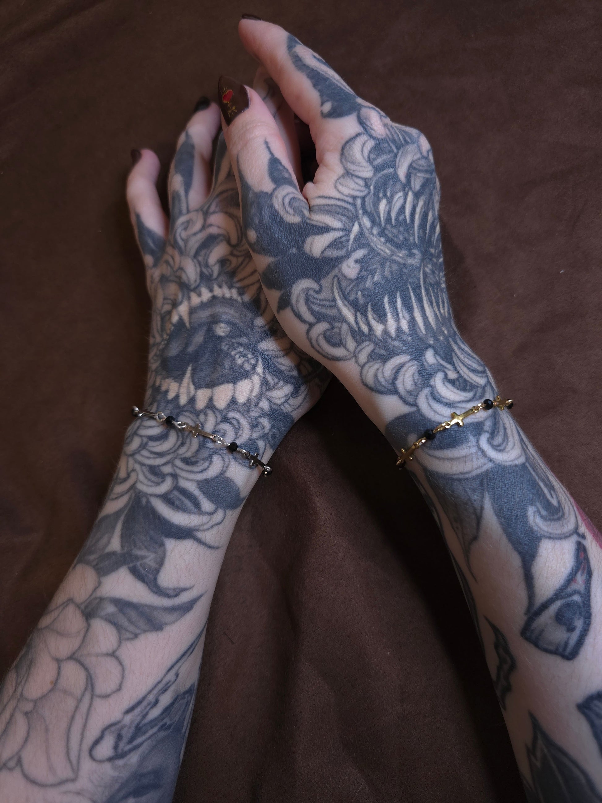 Tattooed arms with intricate designs on a brown background
