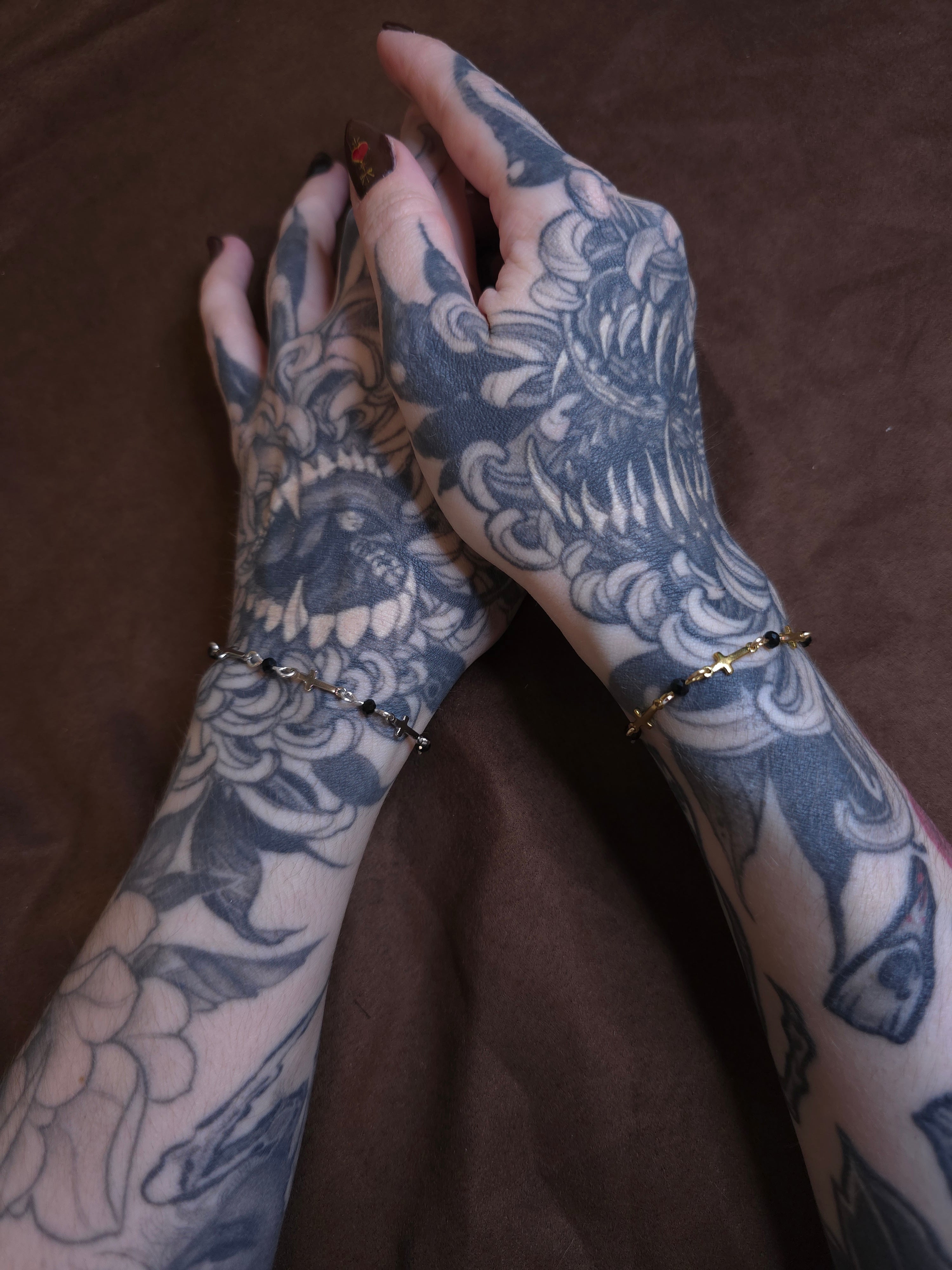 Tattooed arms with intricate designs on a brown background