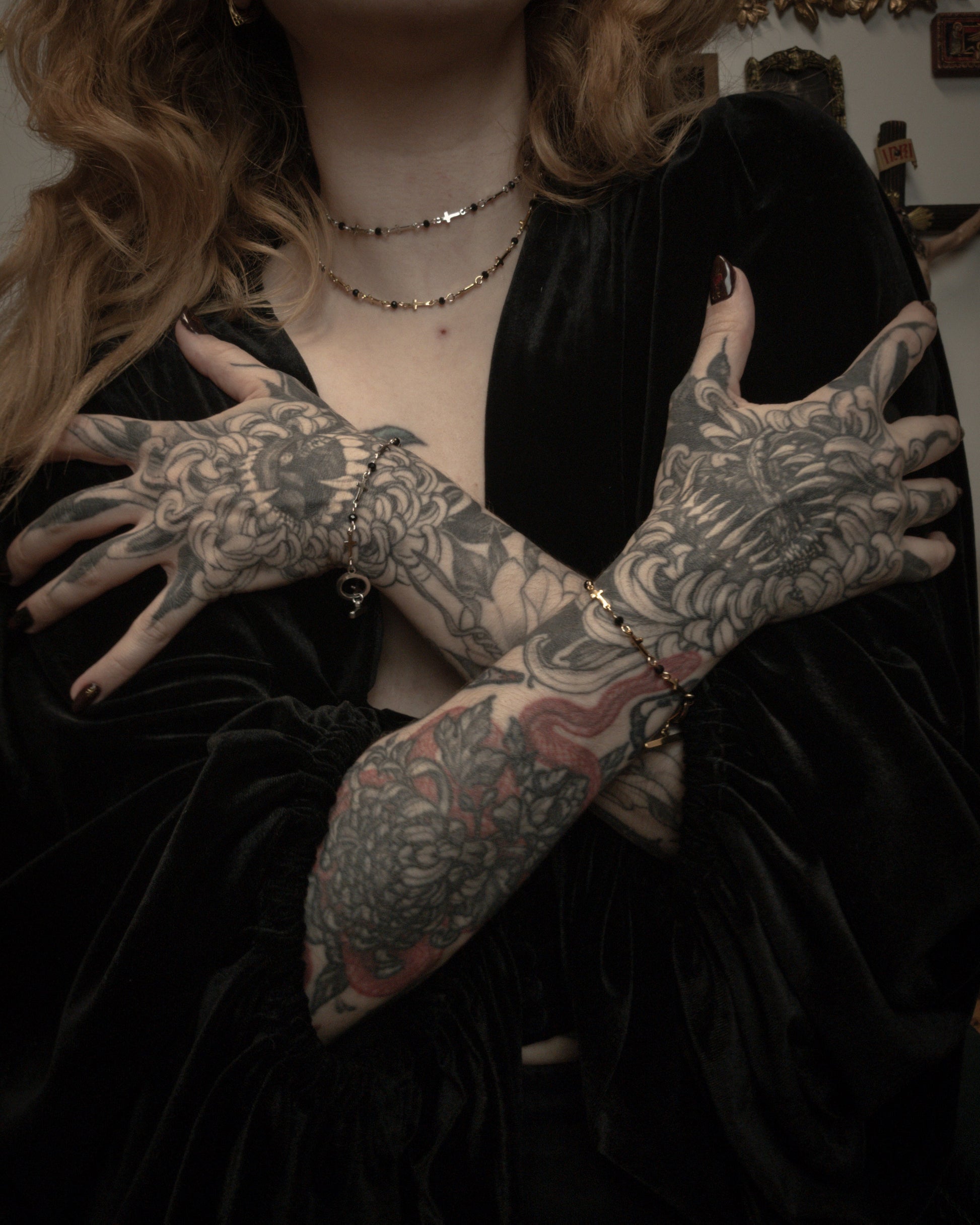 Person with tattooed hands wearing a black outfit.