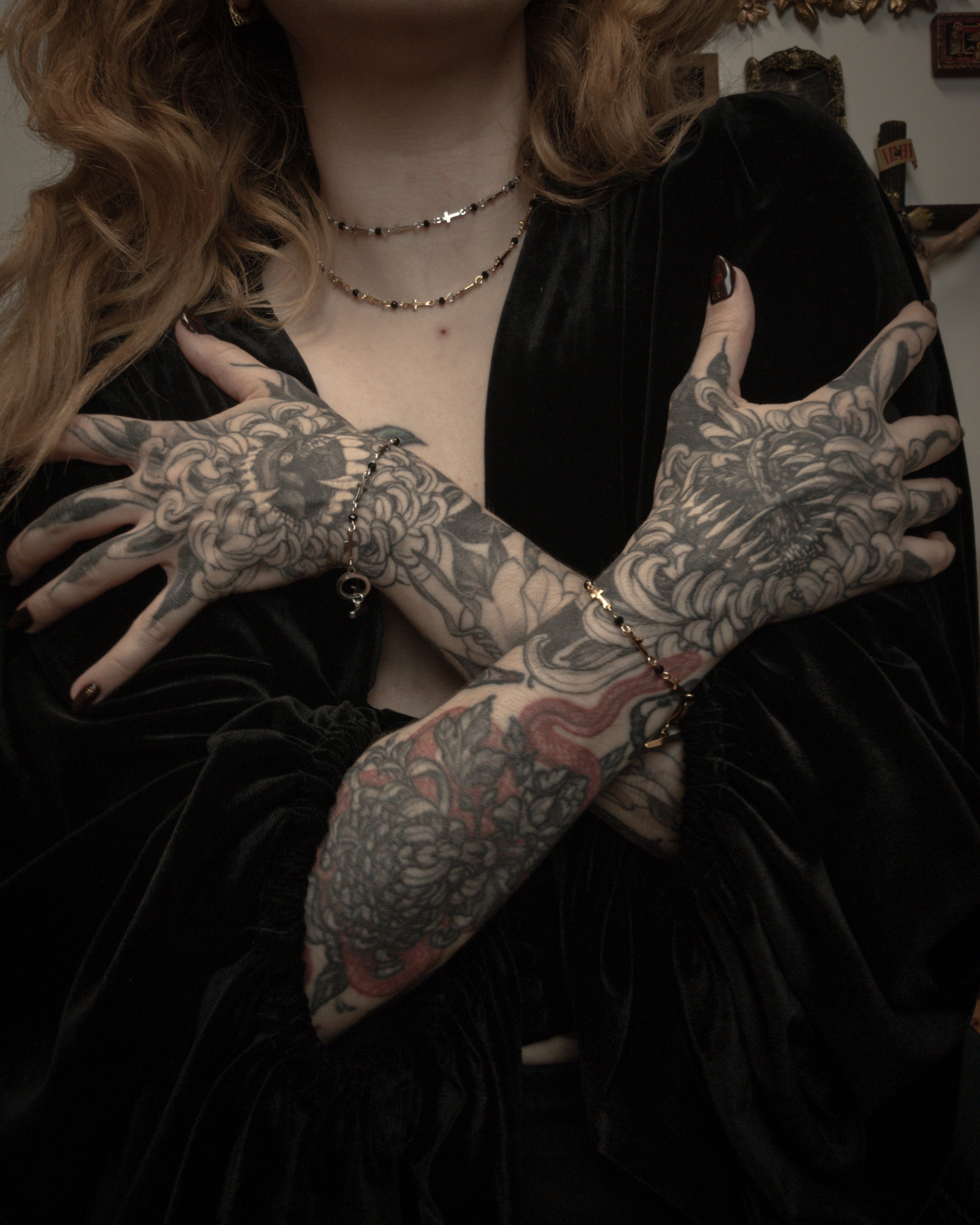 Person with tattooed hands wearing a black outfit.