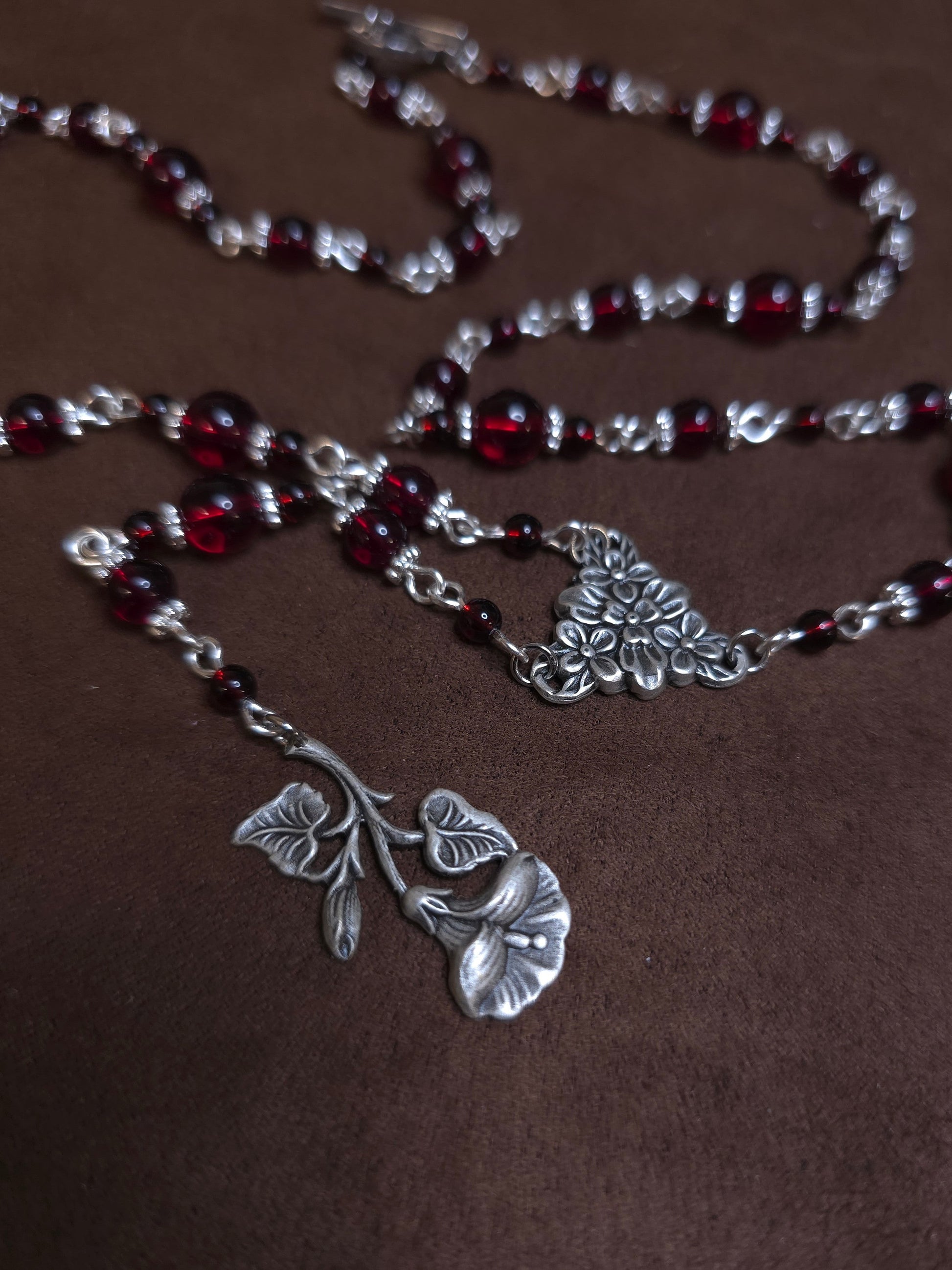 Red beaded rosary with silver flower charms
