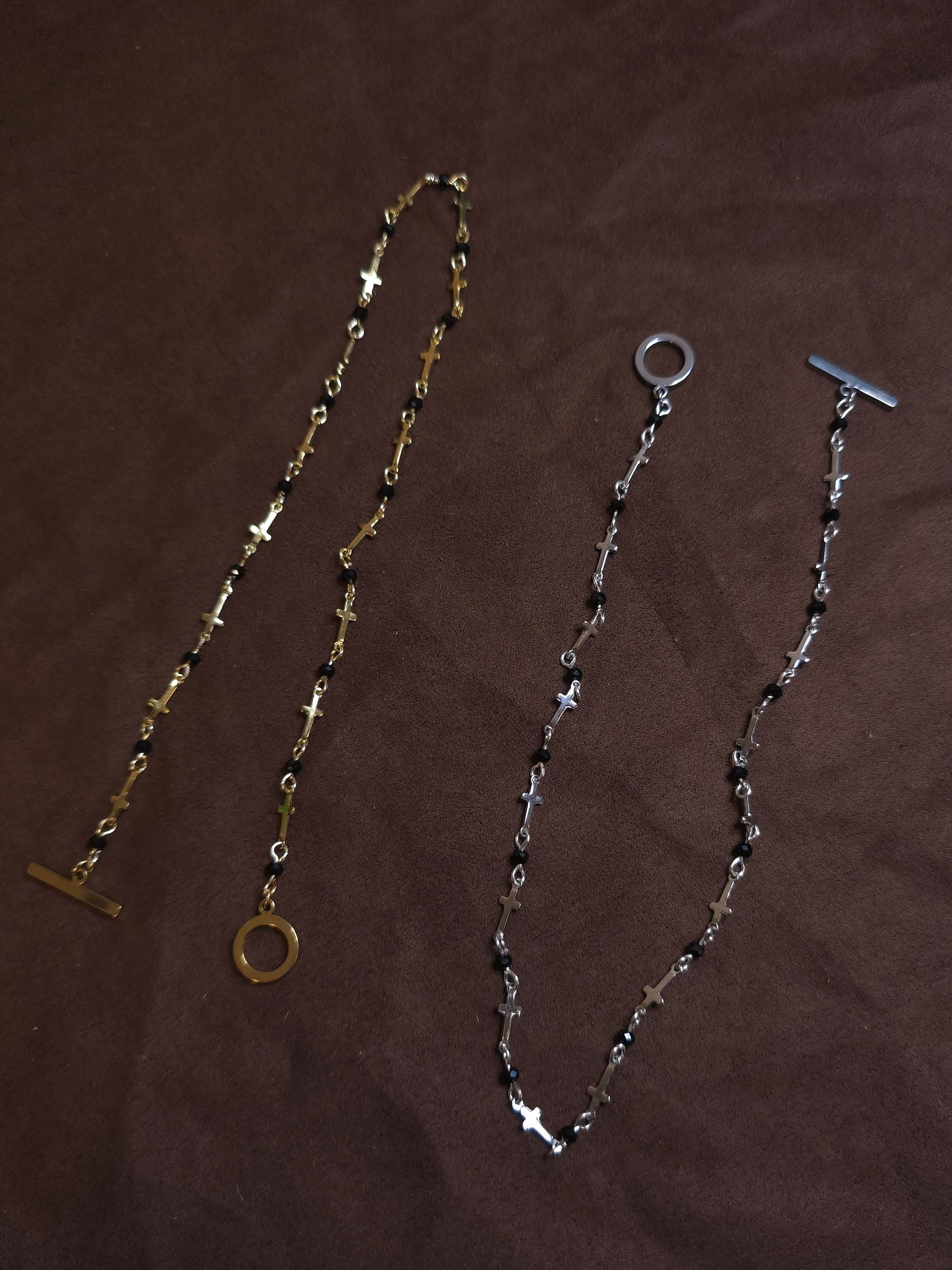 Two necklaces on a brown surface