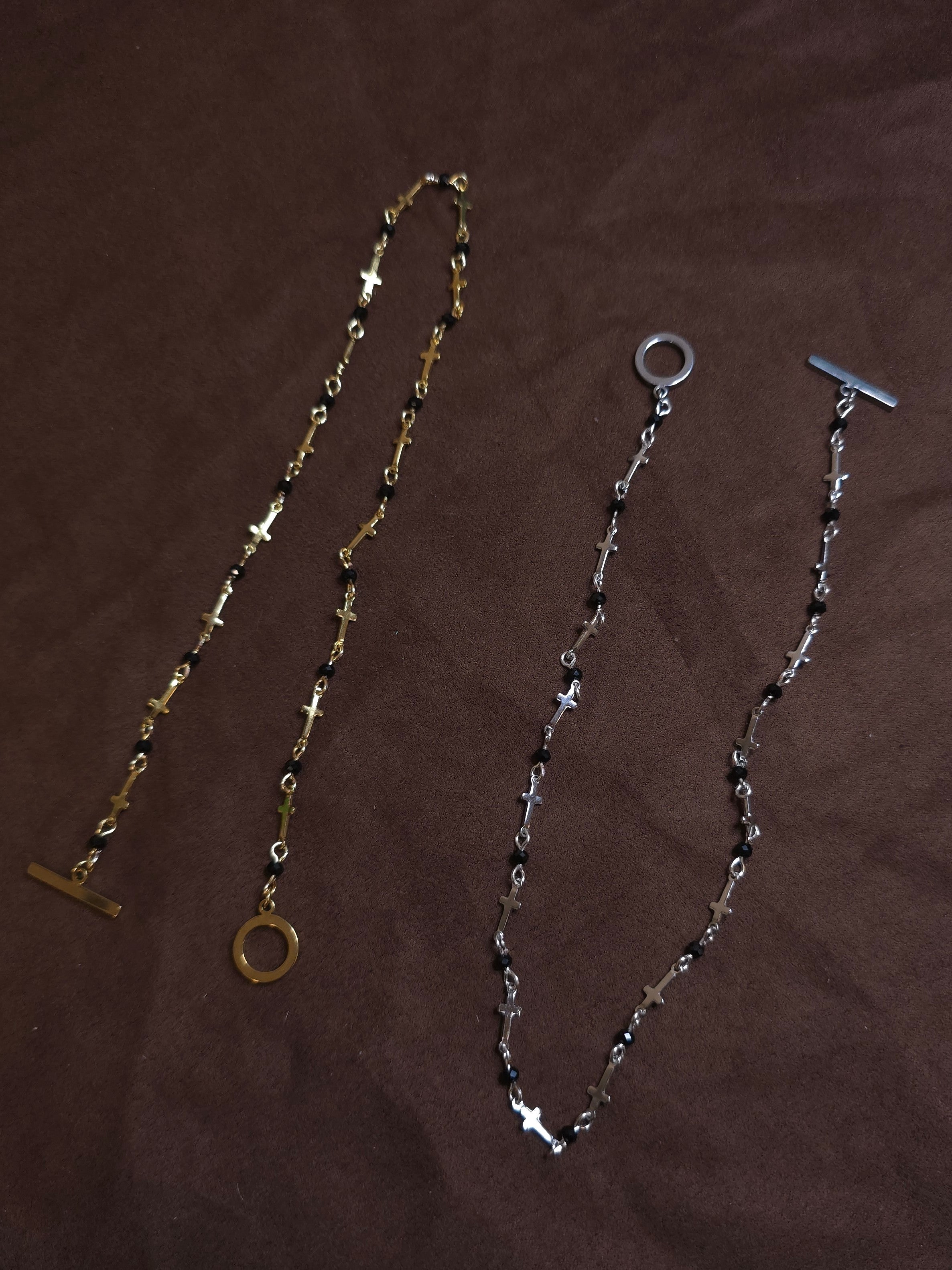 Two necklaces on a brown surface