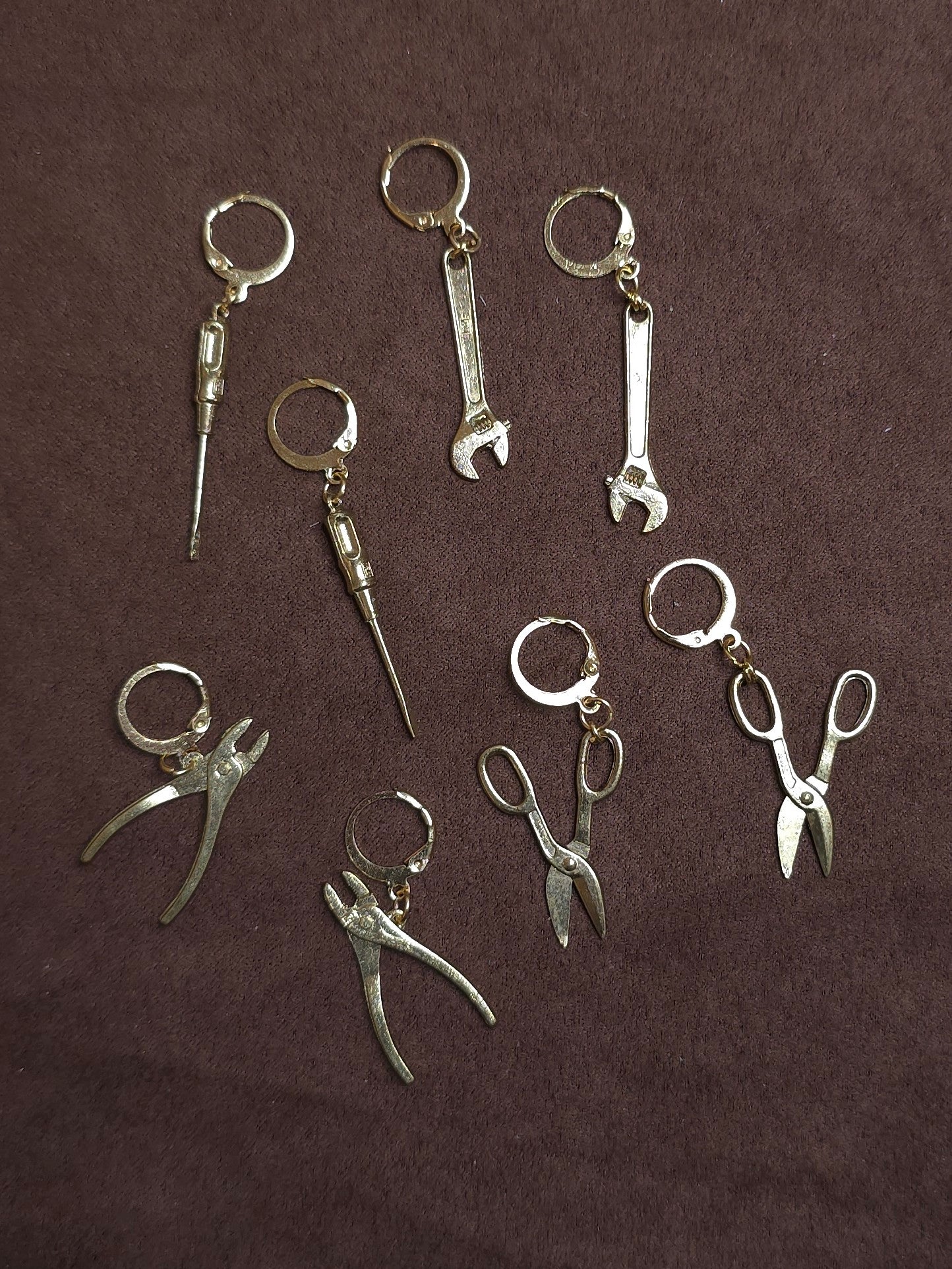 Multiple tool shaped earrings on brown background